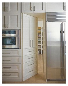 a kitchen with white cupboards and stainless steel refrigerator freezer next to an oven