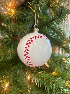 a baseball ornament hanging from a christmas tree