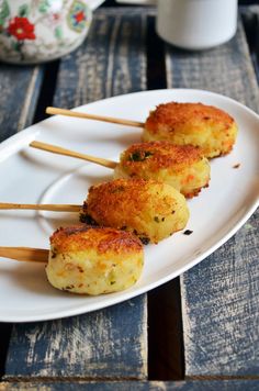 three appetizers are sitting on a white plate with toothpicks in them