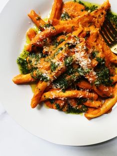 a white plate topped with pasta covered in sauce and parmesan cheese