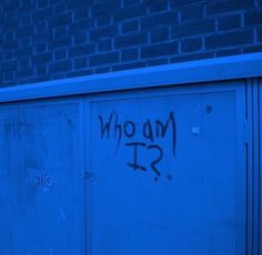 graffiti on the side of a building that says who am i?