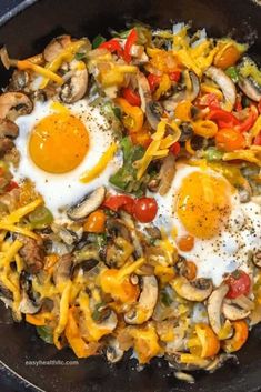 two fried eggs in a skillet with mushrooms, peppers, and cheese on top