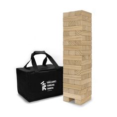 a wooden block tower next to a black bag