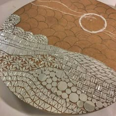 a close up of a plate with a bird on it's side and circles around the edges