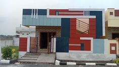 a multicolored house with stairs and balconies on the outside, in front of a parking lot