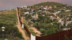 the border fence is built on top of a hill