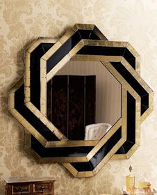 a black and gold mirror sitting on top of a wall next to a wooden dresser