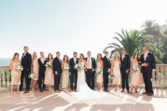 a group of people standing next to each other in front of a balcony with palm trees