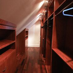 an empty closet with wooden flooring and built - in shelving units on the wall