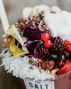 an ice cream sundae with fruit, nuts and chocolate shavings on top