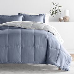 a bed with blue comforter and white pillows