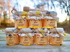 a stack of honey jars sitting on top of a wooden table