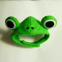 a green frog hat with eyes and nose