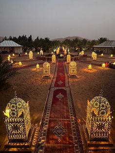 an elaborately decorated walkway in the middle of a desert with lanterns lit up on it