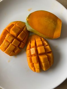 three pieces of mango sitting on top of a white plate