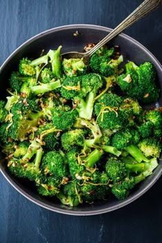 a bowl filled with broccoli on top of a table