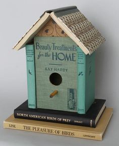 a bird house sitting on top of three books