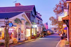 an empty street lined with shops and stores at dusk in the town center on a beautiful fall day