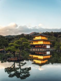 the golden building is surrounded by trees and water