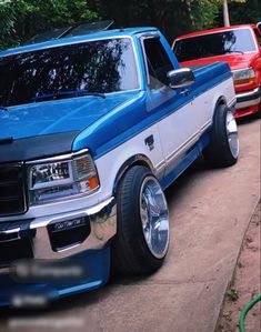 two pickup trucks parked on the side of the road