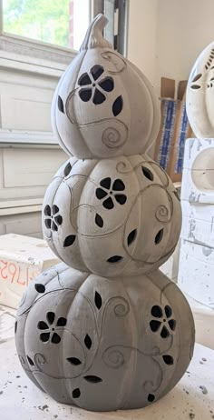 three cement pumpkins stacked on top of each other in the shape of flowers and leaves