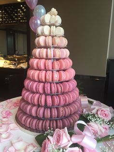 a tower of macaroons and pink roses on a table