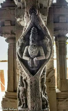 an intricately carved statue is shown in the middle of a stone structure with carvings on it