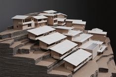 an architectural model of a house on top of stacks of paper