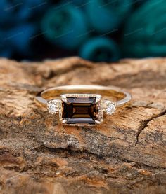 a brown and white diamond ring sitting on top of a rock