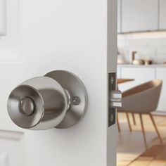 an open door with a handle on it and a kitchen table in the back ground