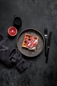 a plate with waffles and blood orange slices