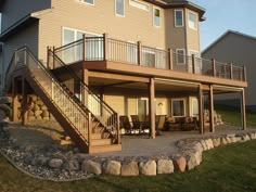 a large house with a deck and stairs leading up to the upper level balcony area