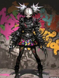 a woman dressed in black and multicolored clothing with spikes on her head, standing against a graffiti covered wall