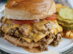 a cheeseburger on a plate with pickles