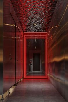 an empty hallway with red and black walls