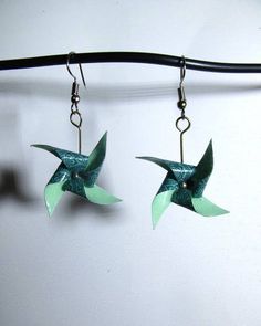 two green origami birds hanging from hooks