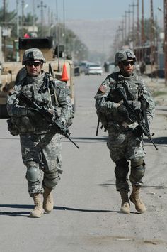 two soldiers are walking down the street