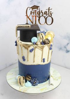 a graduation cake decorated with gold and blue icing