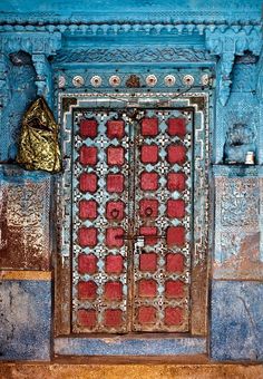 a blue and red door with a gold bag on it