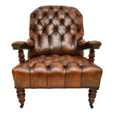 a brown leather chair with wooden legs and buttons on the armrests, against a white background