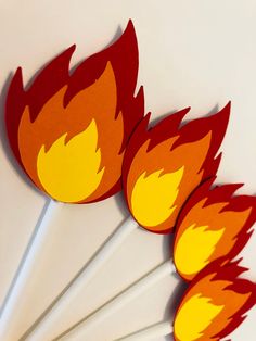 four red and yellow flames on top of each other with toothpicks in the middle