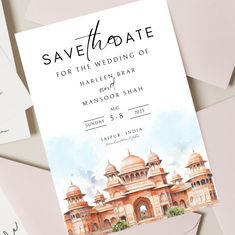 save the date cards with watercolor painting on them and envelopes next to each other