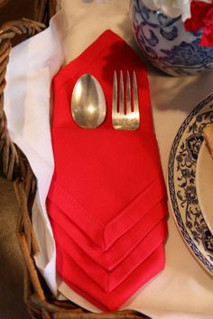 a red napkin and silverware on a table