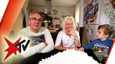 two people sitting at a table with marshmallows in front of the camera