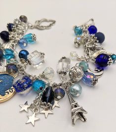 "- Night Time in Paris Charm Bracelet Stainless Steel Chain - can be ordered from 6\" - 9\" Toggle Closure The bracelet links are filled with glass, crystals, and pearls in shades of blue, clear, and silver. Mixed between the crystals and beads are Paris and night sky themed charms. This is a great gift for Anyone who lives Paris! In my store category \"Earrings\", I have created matching earrings. Your bracelet will be carefully gift packaged and shipped via USPS First Class Mail. Feel free to Paris Charm Bracelet, Paris Bracelet, Beautiful Paris, Blue Charm, Paris Blues, China Cups, Homemade Jewelry, Stainless Steel Chain, Resin Jewelry