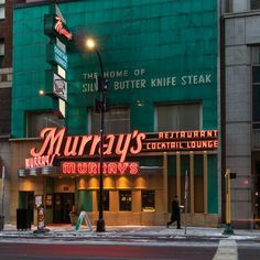 the marquee for mary's restaurant is lit up in red and green