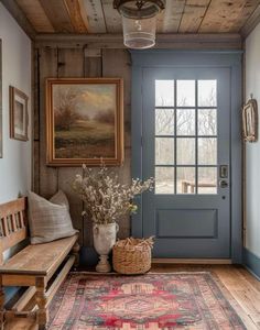 a blue front door with a wooden bench next to it and a rug on the floor