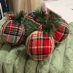 two plaid christmas ornaments sitting on top of a bed