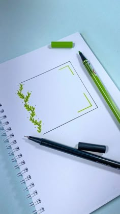 a notepad with a green plant drawn on it next to a pen and a pair of scissors