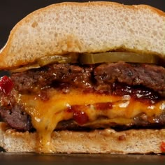 a cheeseburger with pickles and ketchup is shown on a bun